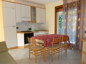 a kitchen with a table and chairs and a kitchen with white cabinets at Villa Cortina in Rosolina Mare