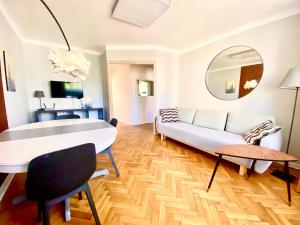 a living room with a white couch and a mirror at Stanislawa Augusta by P&J Apartments in Warsaw