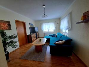 a living room with a blue couch and a table at Ferienhaus Marianne in Zinnowitz