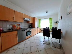 a kitchen with wooden cabinets and a table and chairs at Ferienhaus Marianne in Zinnowitz