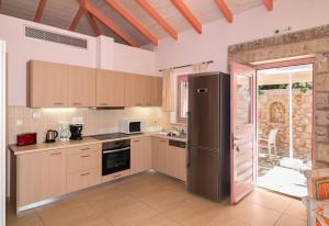 a kitchen with a stainless steel refrigerator in a room at Athena's cottage Stoupa in Stoupa
