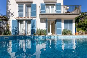 a villa with a swimming pool in front of a house at Apartman Fana in Njivice