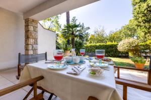 a table with glasses of wine on a patio at Apartman Fana in Njivice