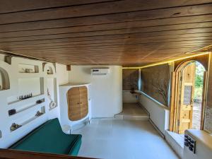 una piccola camera con divano verde e finestra di Cave Canvas a Mount Ābu