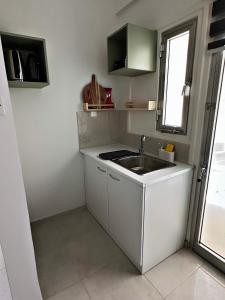 a small kitchen with a sink and a window at Engomi Apartment in Yukarı Lakatamya