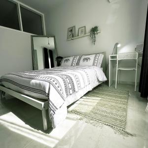 a bedroom with a bed with a mirror and a rug at Engomi Apartment in Yukarı Lakatamya