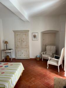 a bedroom with a bed and a chair in it at Maison de caractère rénovée Coggia in Coggia