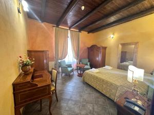 a hotel room with a bed and a desk and a table at Palazzo Marzano in Briatico