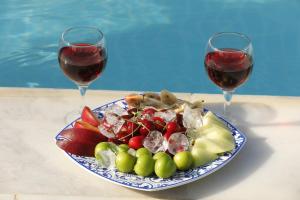 two glasses of wine next to a plate of fruit at Nu-se Garden Butik Otel in Selcuk