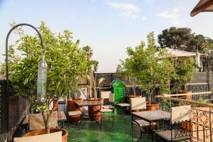 an outdoor patio with tables and chairs and trees at Riad Anya & SPA in Marrakesh