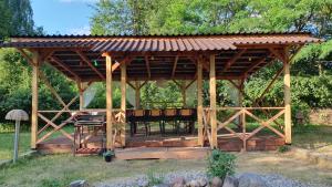 a wooden gazebo with a table and chairs at Wiolinkowo in Sarnaki