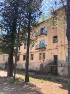 a tan building with a balcony on the side of it at Уютная квартира в Цхалтубо in Tskaltubo