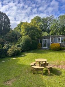 a picnic table and two benches in a yard at Rosie's cottage in Woolfardisworthy
