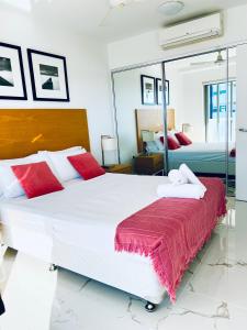 a bedroom with two beds and a mirror at Harmony Accommodation in Townsville +13 photos