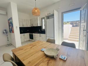 a kitchen and dining room with a wooden table at Santana Apartments in Perivolos