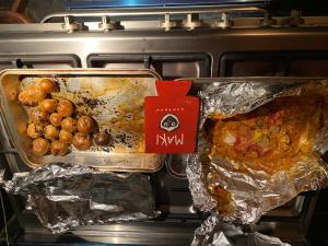 an oven with a tray of food and some potatoes at Le Maki on 54 in Johannesburg