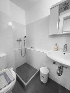 uma casa de banho branca com um lavatório e um WC em MATEOS APARTMENT WINDMILLS TOWN em Míconos
