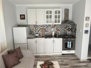 a kitchen with white cabinets and a stove top oven at Villa Sea House in Byala +11 photos