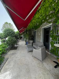 a patio with chairs and a red umbrella at Hotel Clair de Lune in Zonza