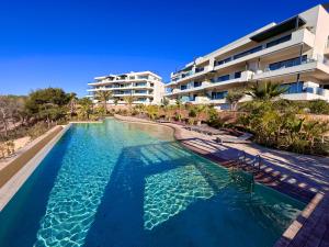 a swimming pool in front of a building at Casa Torwoods Las Colinas in Orihuela Costa