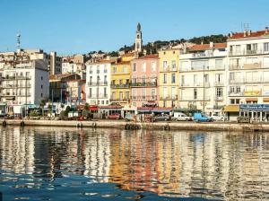 un groupe de bâtiments à côté d'une masse d'eau dans l'établissement Sète Plage Corniche, à Sète