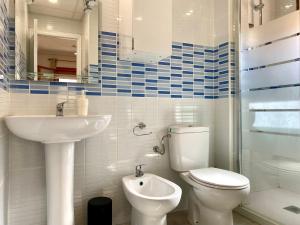 a white bathroom with a toilet and a sink at La Mata beach apartment Viñamar I, 200m from the beach in La Mata +43 photos