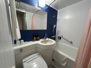 a bathroom with a white toilet and a sink at Hotel 1-2-3 Kurashiki in Kurashiki