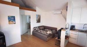 a living room with a couch and a kitchen at Green Garden , HOMEANDSAIL in Jezera