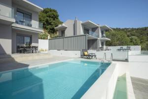 a swimming pool in front of a house at Aloft Luxury Villas Lefkada - Heated pool Lefkia Villa in Apolpaina