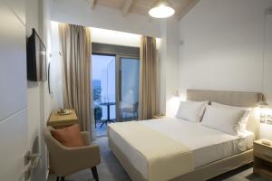 a bedroom with a bed and a chair and a window at Aloft Luxury Villas Lefkada - Heated pool Lefkia Villa in Apolpaina