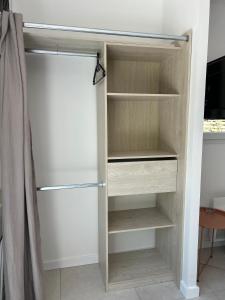 a closet with wooden shelves in a room at Studio avec terrasse privative in Pessac