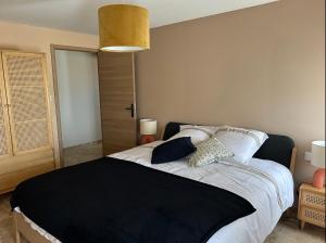 a bedroom with a bed with a black blanket on it at Maltus - Le Repaire de Maltus "Gîtes & Spa" in Lussac