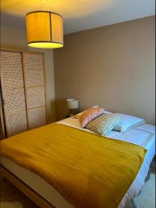 a bedroom with a large bed with a yellow blanket at Maltus - Le Repaire de Maltus "Gîtes & Spa" in Lussac