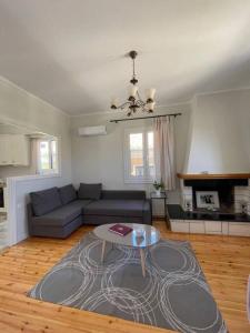 una sala de estar con un sofá y una mesa en To Patriko Lefkada Cozy Village Home with Parking, en Tsoukaladhes