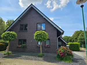 a black house with two trees in front of it at Strandhaus am See in Kalkar