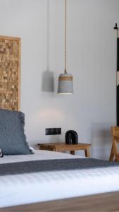 a bedroom with a bed with a blue pillow and a lamp at Cavalier Suites Nikiana Lefkada AV Properties in Nikiana