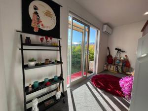 a room with shelves and a window with a view at CBD 2 Bedroom Parkside Living By Hagley with Free Parking in Christchurch