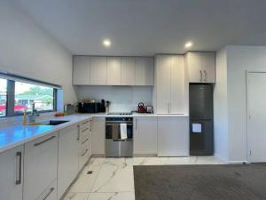 a kitchen with white cabinets and stainless steel appliances at CBD 2 Bedroom Parkside Living By Hagley with Free Parking in Christchurch