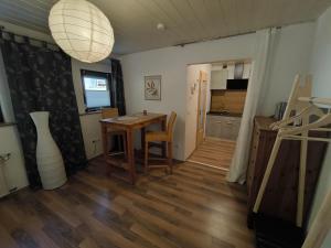 a living room with a table and a kitchen at Haus Bahlo - Ferienwohnungen in Attendorn