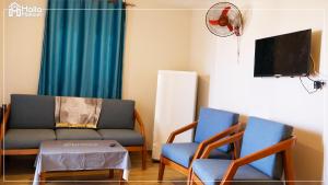 a living room with two chairs and a couch and a tv at Halla Matrouh Sea View in Marsa Matruh