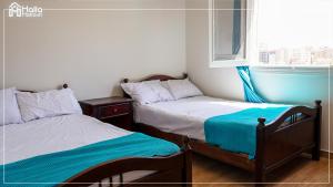 two twin beds in a room with a window at Halla Matrouh Sea View in Marsa Matruh