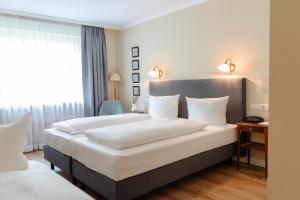 a hotel room with two beds and a window at Hotel Altmünchen by Blattl in Munich