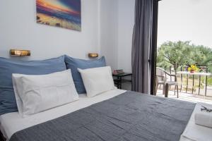 a bedroom with a bed with blue and white pillows at Casa Angelina 2 in Laganas
