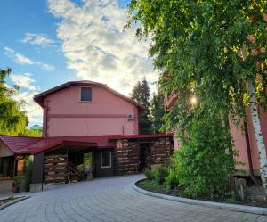 a pink building with a driveway in front of it at Апартаменти-студіо в Трускавці in Truskavets