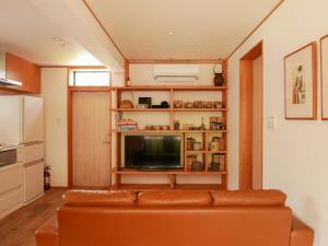 a living room with a couch and a television at Akizuki Meganebashi Cottage in Asakura