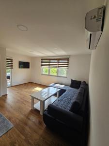 a living room with a couch and a table at Apartmani gradina Tuzla in Tuzla