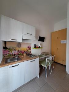 a kitchen with a sink and a table with chairs at B&B Fior di Mare in Porto Cesareo