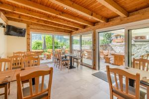 a dining room with tables and chairs and windows at Penzion Hosnar in Bovec