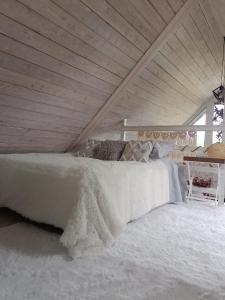 a bedroom with a bed with white blankets and pillows at Izbicki ZaKątek- Izbica nad jeziorem Łebsko in Speck