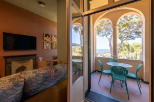 Una habitación con balcón con mesa y sillas. en Villa Rappis, en Imperia